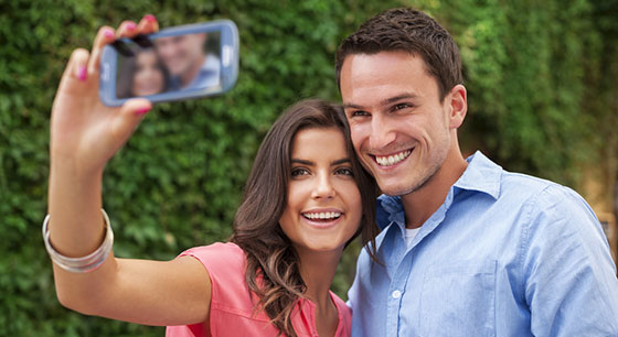 happy couple taking selfie with smartphone